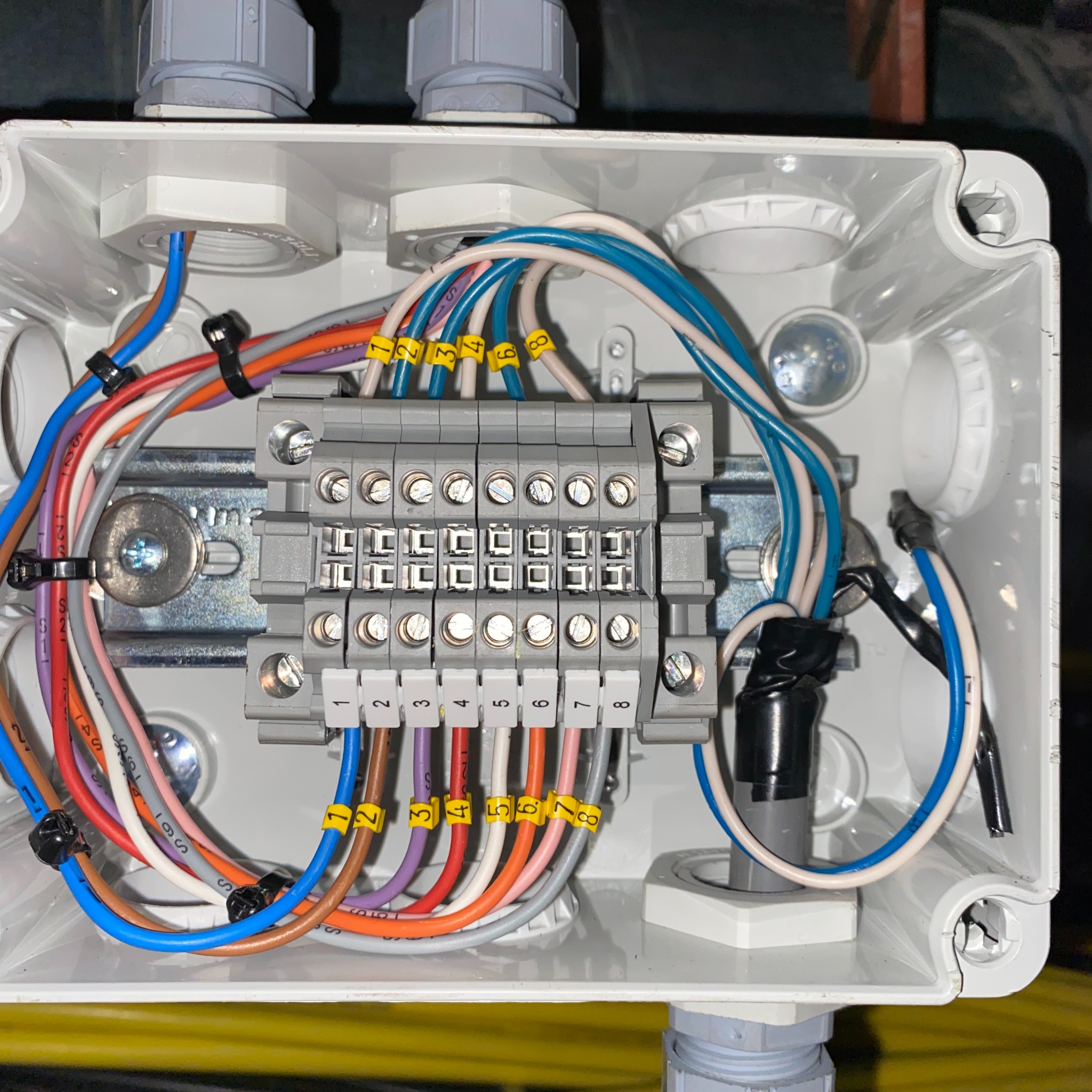 Rozdzielnica elektryczna z numerowanymi przewodami w skrzynce, widok z góry. Precyzyjne połączenia w instalacji elektrycznej w Poznaniu.