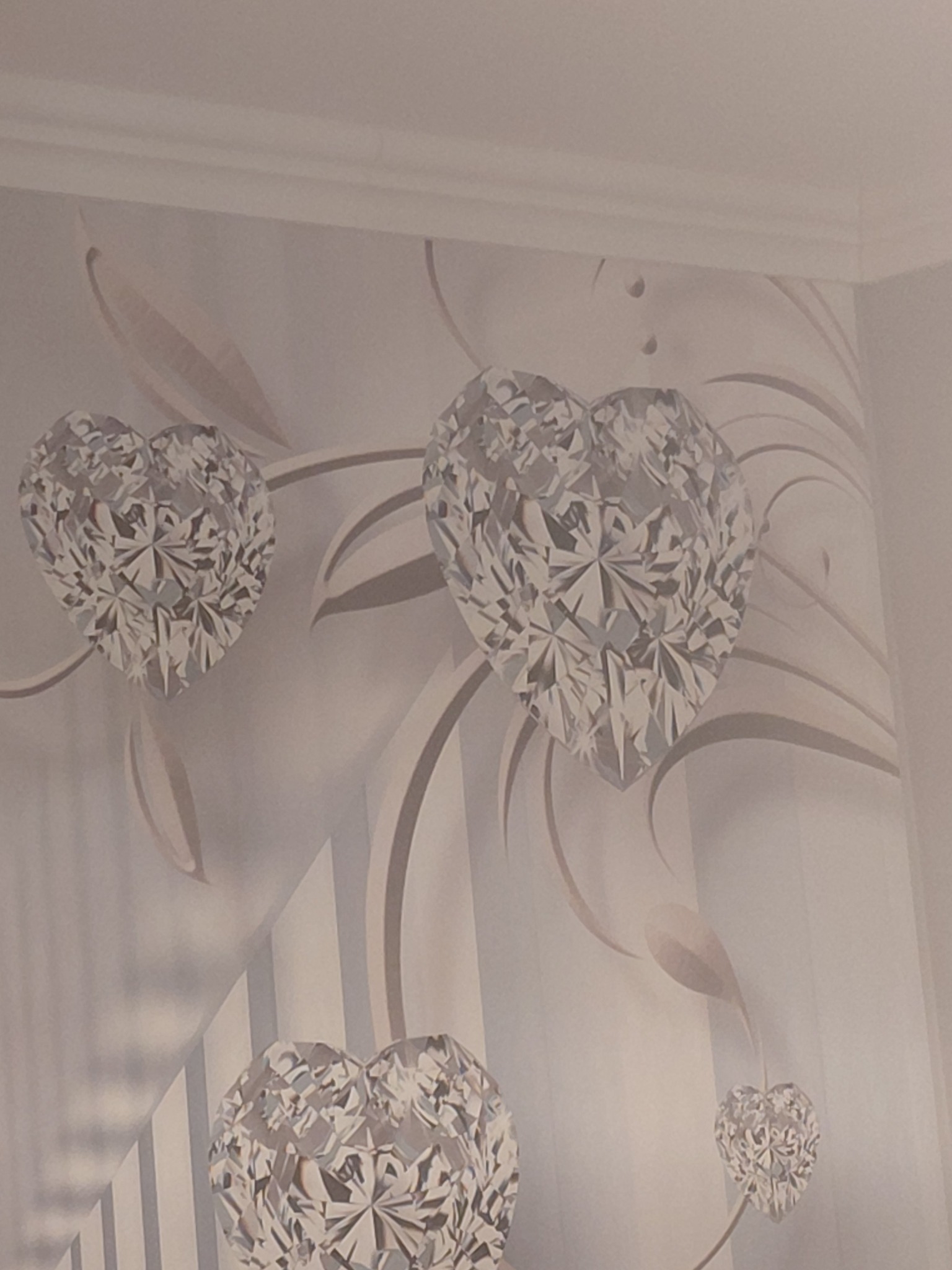 Delikatny wzór na ścianie: tapeta w odcieniach bieli i szarości z motywem diamentowych serc i abstrakcyjnych, roślinnych ornamentów. Subtelne przejścia tonalne.