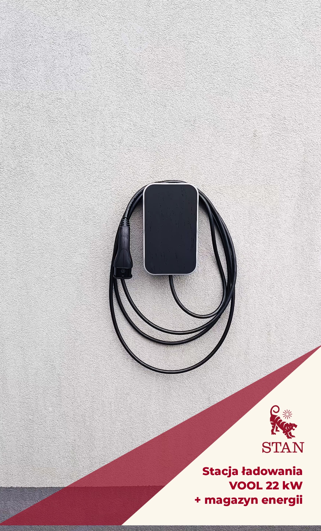 Zamontowana stacja ładowania VOOL 22 kW w Krakowie. Czarna obudowa z kablem na jasnej ścianie. Widoczny fragment logotypu firmy.