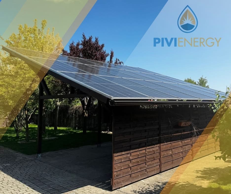 Zadaszenie z panelami słonecznymi na tle błękitnego nieba i zieleni drzew. Widoczne drewniane elementy konstrukcyjne i kostka brukowa. Instalacja fotowoltaiczna.