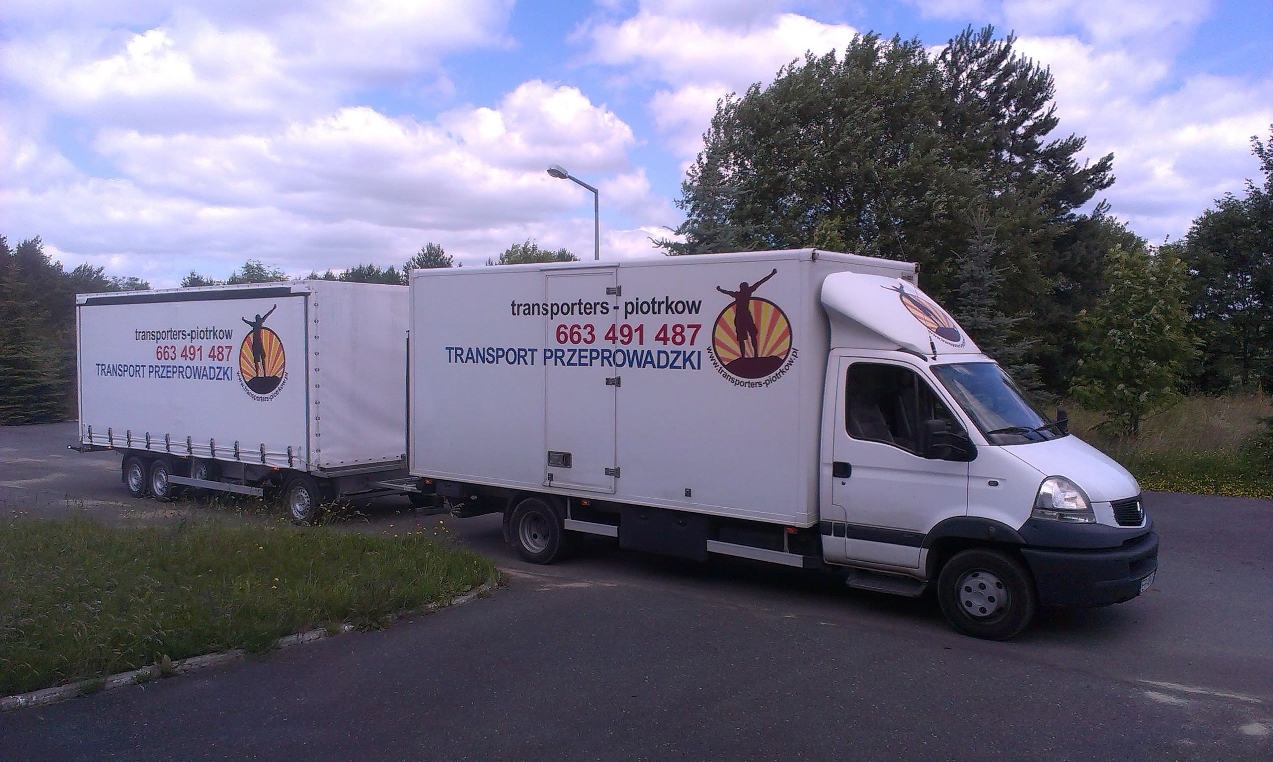 Biały samochód dostawczy z przyczepą kontenerową firmy z Piotrkowa Trybunalskiego, z widocznym logo i numerem telefonu, zaparkowany na asfalcie w otoczeniu zieleni.
