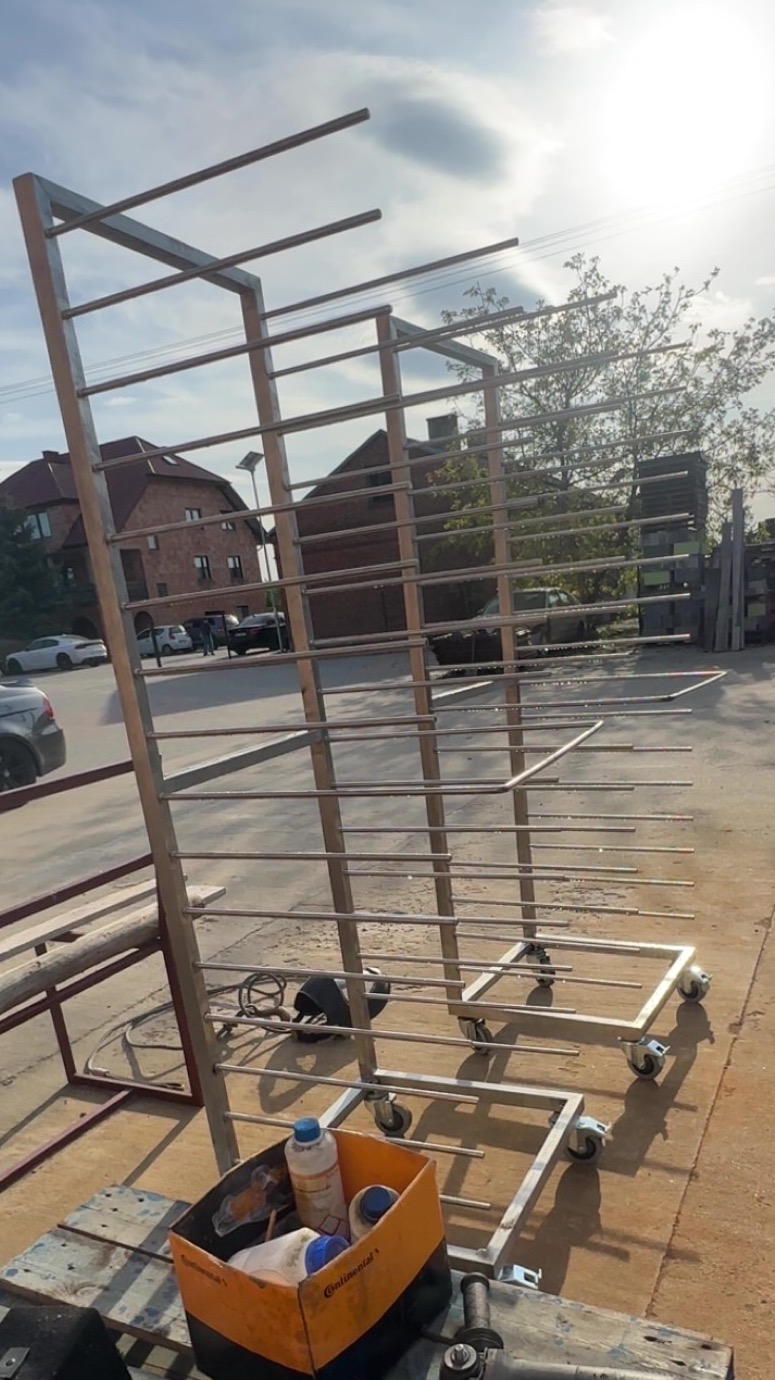 Konstrukcja metalowa na kółkach, prawdopodobnie w trakcie tworzenia, widoczna w Brzozowie Nowym. Elementy spawane, surowe wykończenie, narzędzia w tle.