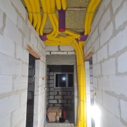 Na zdjęciu przedstawiono montaż systemu rekuperacji Max Vent z zastosowaniem rur Spectra 1000. Widać elastyczne żółte przewody wentylacyjne doprowadzone do fioletowych rozdzielaczy systemowych.