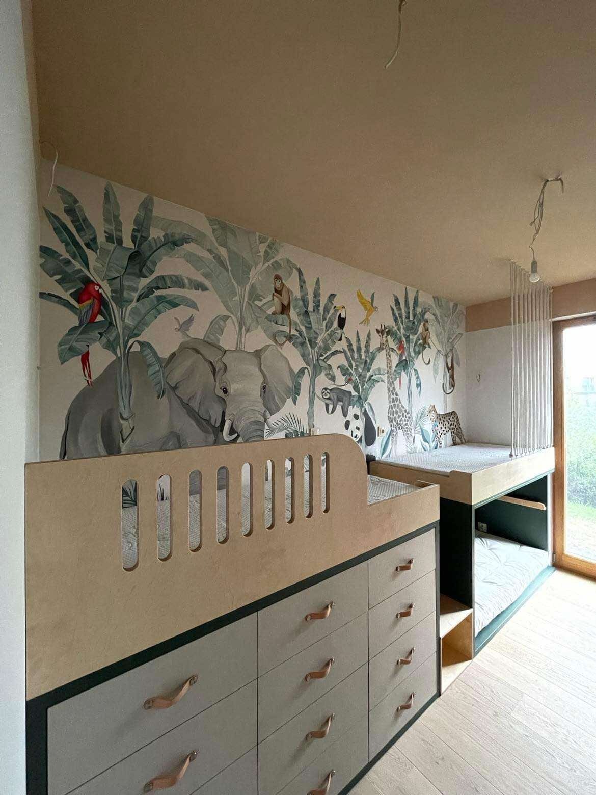 Pokój dziecięcy z łóżkiem piętrowym i tapetą w motywy dżungli: szafki z szufladami, drewniane wykończenia, egzotyczne zwierzęta na ścianie.