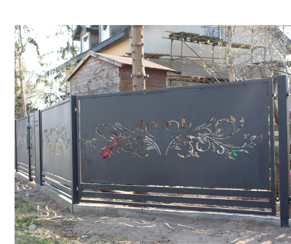 Nowoczesne ogrodzenie metalowe z dekoracyjnym, ażurowym wzorem roślinnym na tle domu i drzew. Szara kolorystyka, poziome elementy konstrukcyjne.