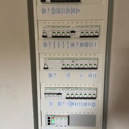 POLTHOM Paweł Kietla - Rozdzielnica elektryczna Schneider z opisami obwodów, widoczne wyłączniki różnicowoprądowe i bezpieczniki. Instalacja wewnątrz budynku, widok z bliska.