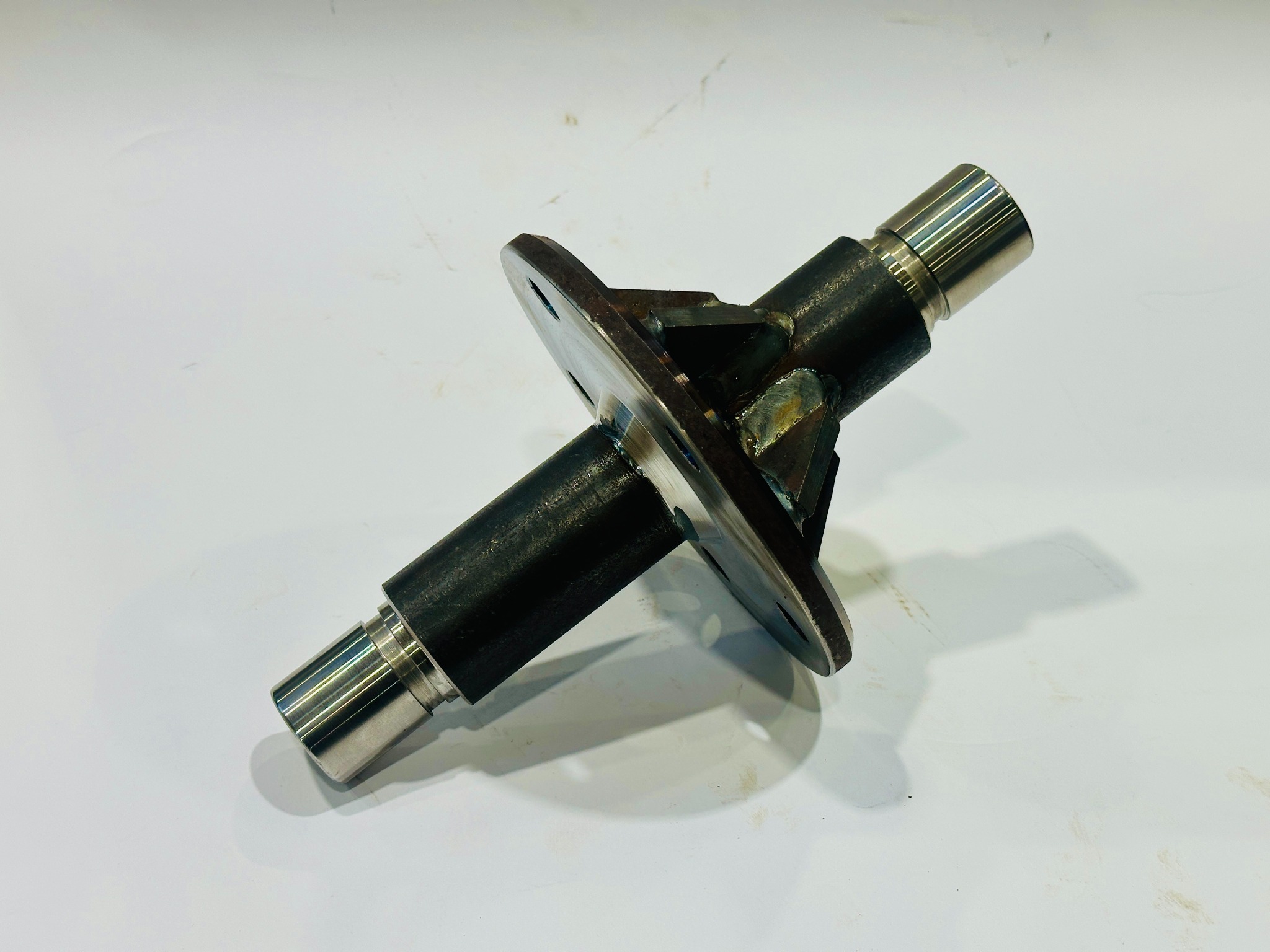 Precyzyjnie wykonany, spawany element metalowy z kołnierzem, obrobiony tokarsko w Pawonkowie. Widoczne spawy i detale obróbki.