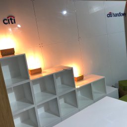 extremePROJECT Alicja Świerczyńska - Białe, modułowe regały z podświetleniem LED i logo Citi Handlowy na białej ścianie, prawdopodobnie element ekspozycji targowej lub reklamowej.