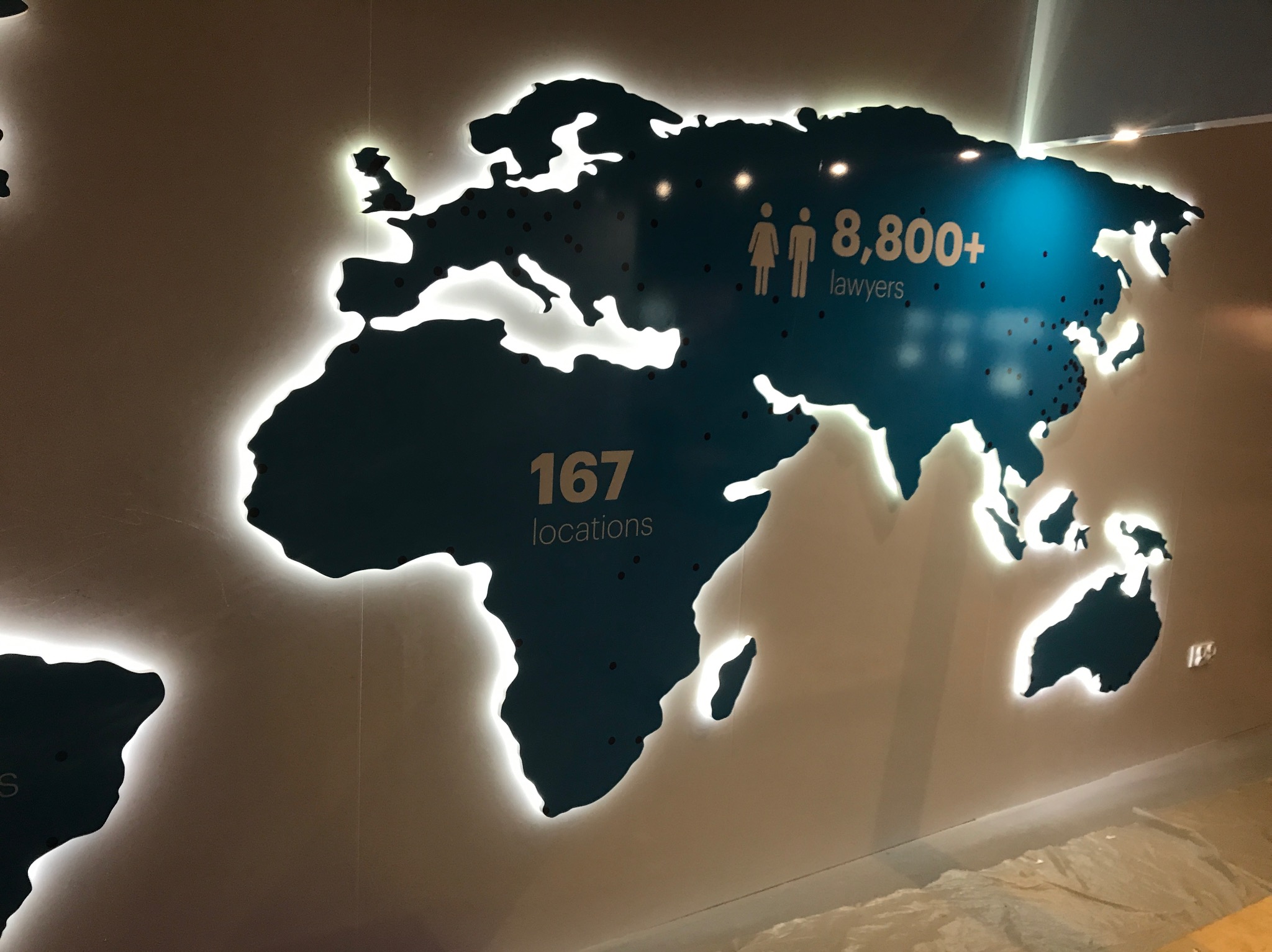 Podświetlana mapa świata z zaznaczonymi lokalizacjami i informacją o liczbie prawników: 8800+ i 167 lokalizacjach.