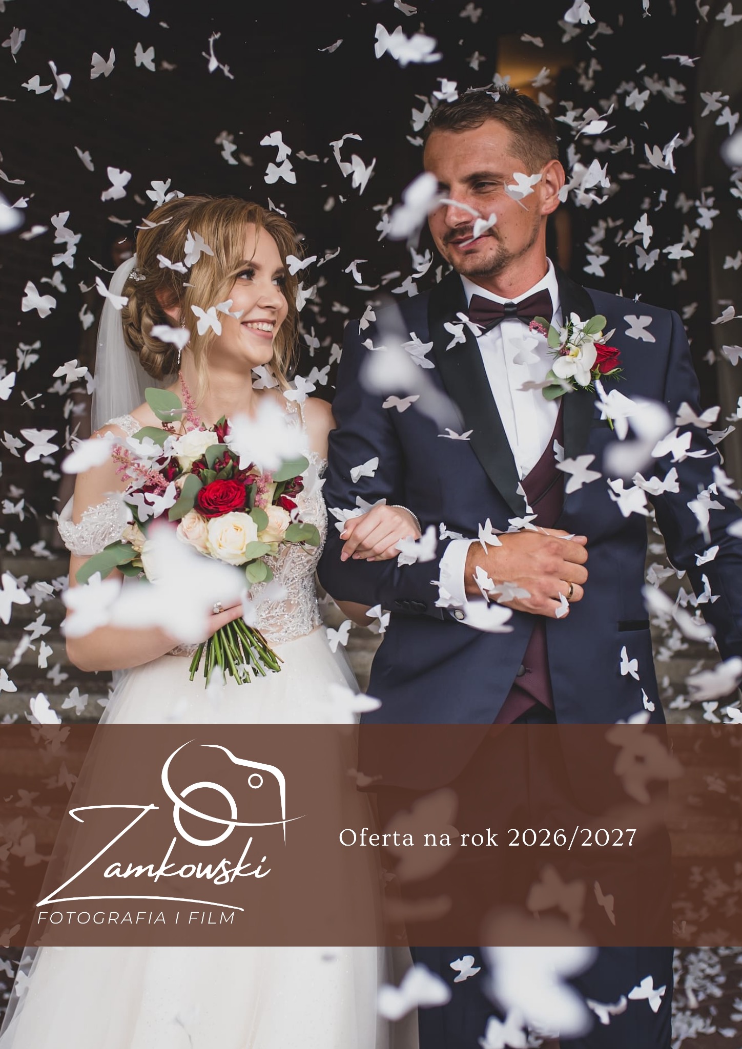 Uśmiechnięta para młoda w deszczu konfetti w kształcie motyli. Panna młoda trzyma bukiet. Oferta na rok 2026/2027.