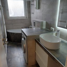 Marcin Głowiak - Nowoczesna łazienka z szarymi płytkami, owalną umywalką nablatową i pralką w zabudowie. Lustro z podświetleniem LED. Minimalistyczny design.