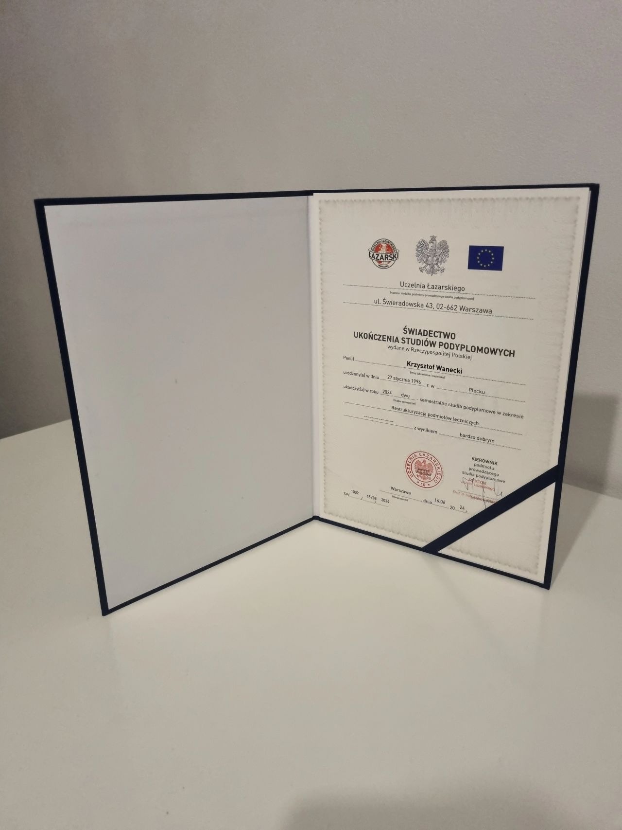 Otwarty dyplom ukończenia studiów podyplomowych z zakresu restrukturyzacji podmiotów leczniczych, wydany przez Uczelnię Łazarskiego w Warszawie.