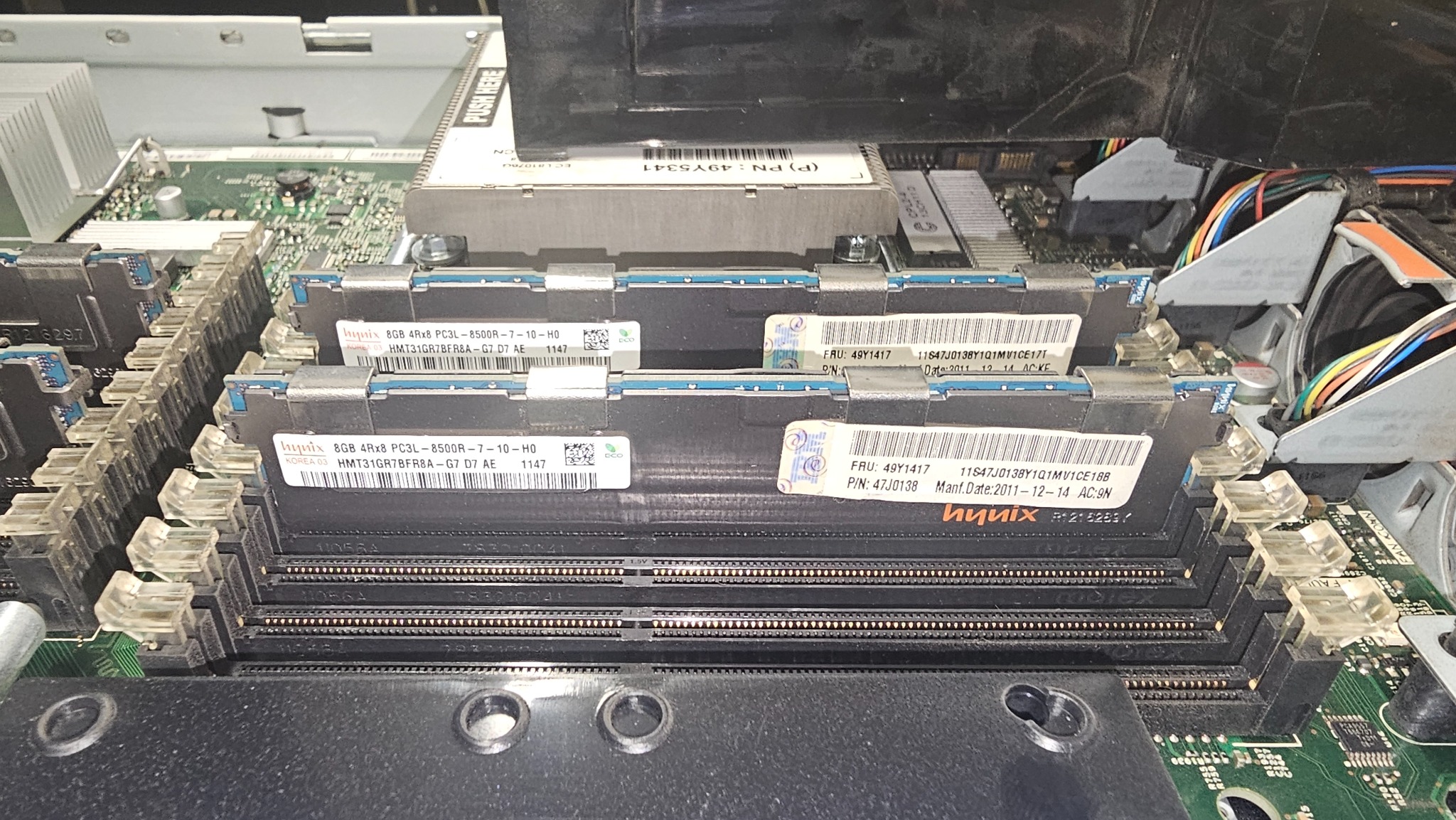 Zamontowane moduły pamięci RAM Hynix 8GB w gniazdach płyty głównej serwera. Widoczne naklejki z numerami seryjnymi i datą produkcji.