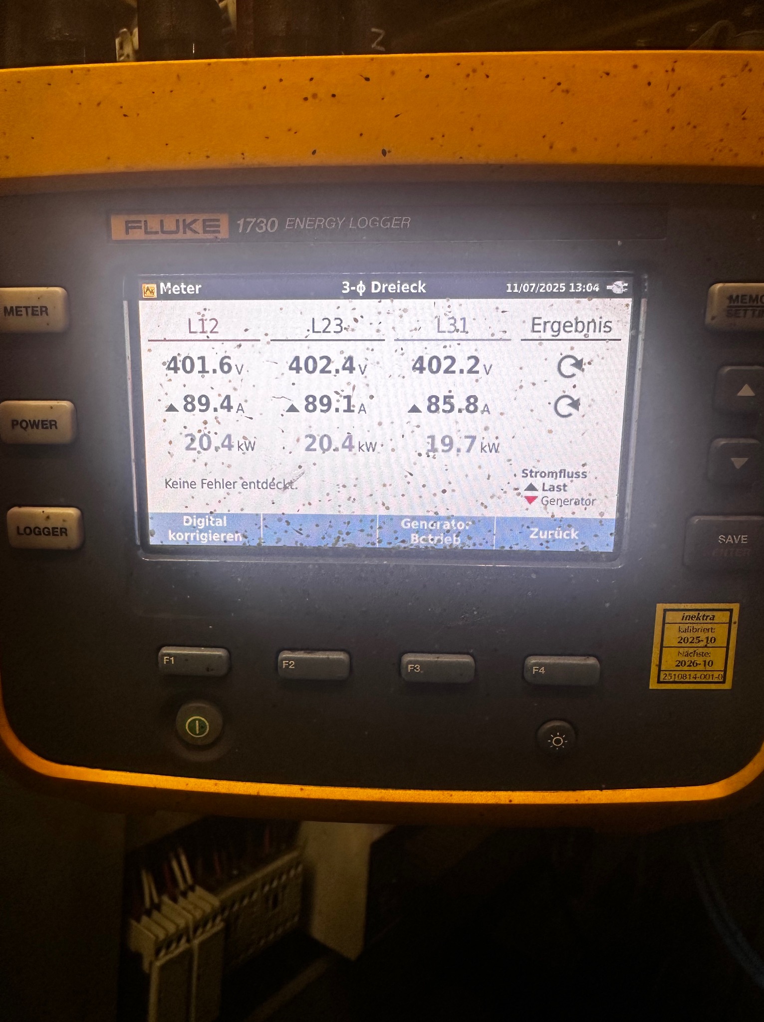 Żółty miernik Fluke 1730 Energy Logger z wyświetlaczem pokazującym pomiary napięcia (401.6V, 402.4V, 402.2V) i prądu (89.4A, 89.1A, 85.8A) w instalacji trójfazowej.