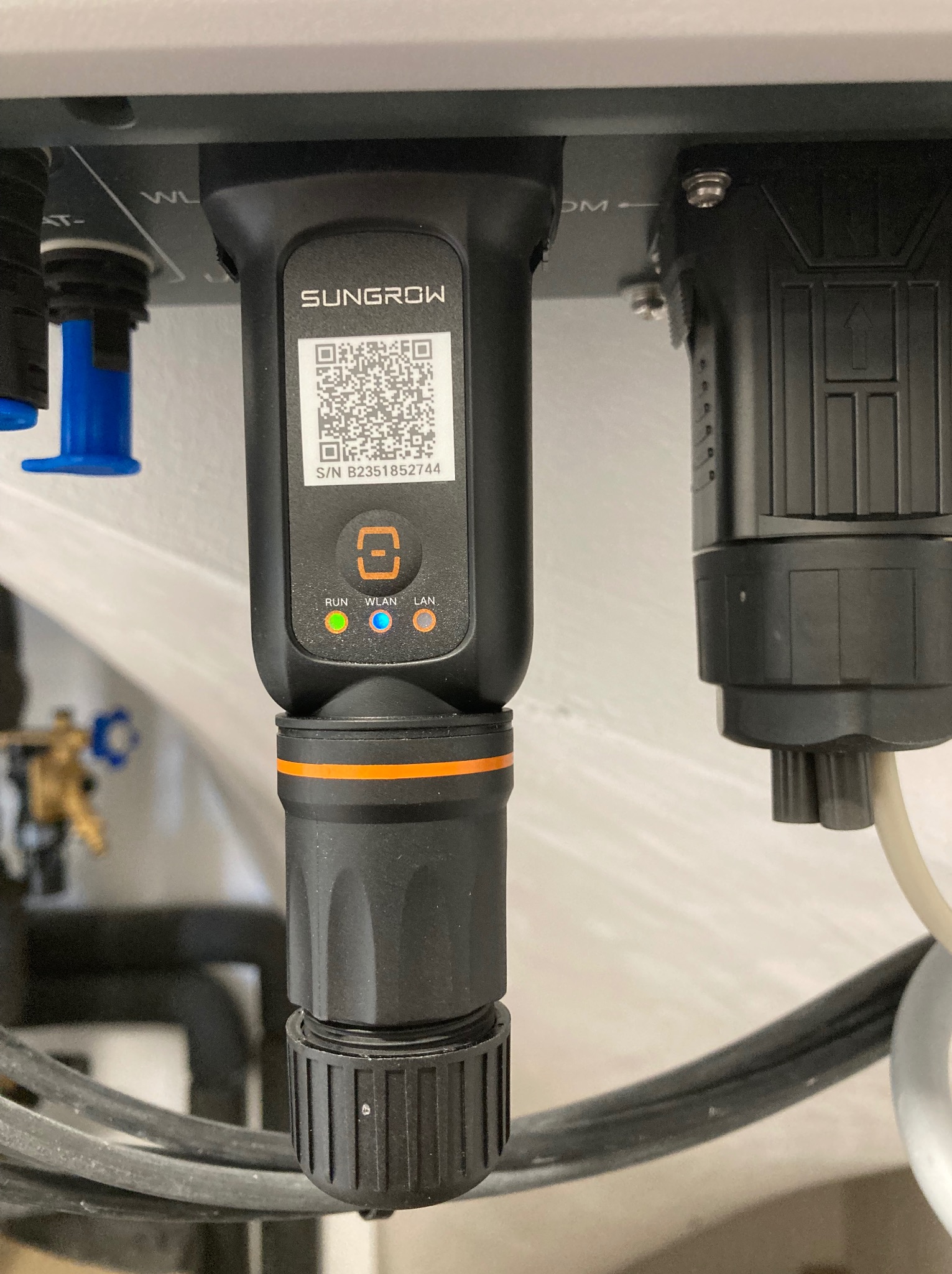 Szczegółowe ujęcie podłączenia modułu Sungrow z kodem QR i diodami LED (RUN, WLAN, LAN) w instalacji elektrycznej w Gdyni. Widoczne złącza i przewody.