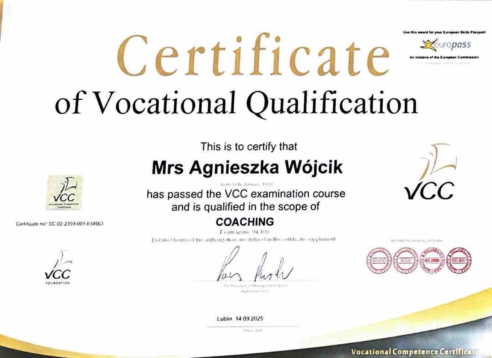 Certyfikat kwalifikacji zawodowych VCC dla Agnieszki Wójcik w zakresie coachingu. Dokument z logotypami VCC i Europass, podpisany, z datą ważności 14.09.2025.
