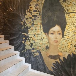 RENOVUM SPÓŁKA Z OGRANICZONĄ ODPOWIEDZIALNOŚCIĄ - Schody z okładziną ceramiczną i dekoracyjna mozaika ścienna z portretem kobiety w stylu art deco, złote akcenty.