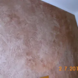 Ściana z dekoracyjną, brązowo-beżową strukturą, widoczny narożnik sufitu i fragment daty 2.7.2013 w prawym dolnym rogu.