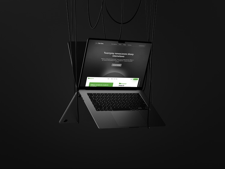Laptop z wyświetloną stroną internetową w odcieniach szarości i zieleni, zawieszony na czarnych kablach na ciemnym tle. Minimalistyczny design, nowoczesny wygląd.