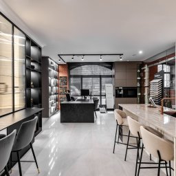 Wera Wysk Fotografia - Nowoczesne wnętrze: marmurowe blaty, eleganckie krzesła barowe, oświetlenie punktowe i przeszklone szafy w zabudowie. Przestrzeń biurowa z elementami ekspozycji.