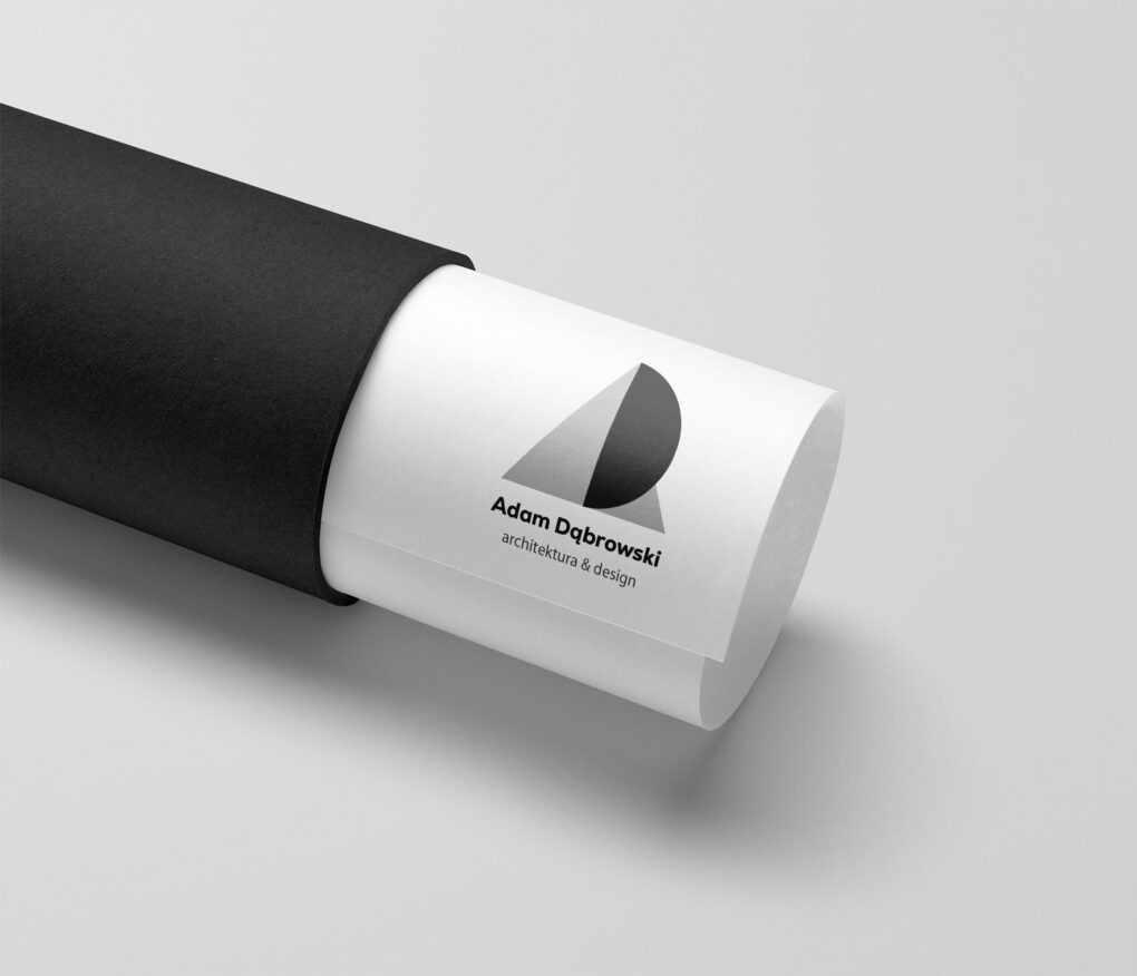 Minimalistyczne logo architektoniczne 'Adam Dąbrowski architektura & design' na zwiniętym planie, wysuniętym z czarnej tuby na jasnym tle.