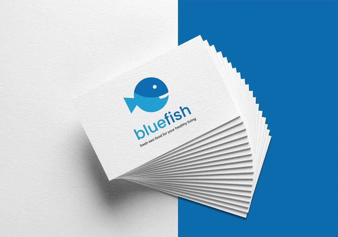 Stos wizytówek z logo 'bluefish', przedstawiającym niebieską rybę i hasłem 'fresh sea food for your healthy living', na białym i niebieskim tle.