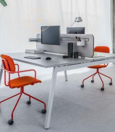 Nowoczesne biuro z szarym biurkiem, pomarańczowymi krzesłami i przegrodą akustyczną. Minimalistyczny design, jasne tło, ergonomiczne stanowisko pracy.