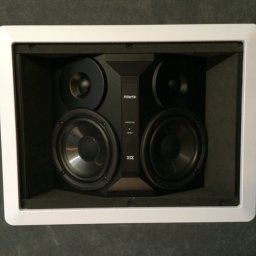 KRC TRADING GROUP SP. Z O.O. - Wbudowany w ścianę głośnik audio marki Atlantic Technology, model IW-260, z białą ramką, widoczny z bliska, na tle szarej ściany. Dwa głośniki niskotonowe i dwa wysokotonowe.