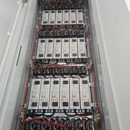 KRC TRADING GROUP SP. Z O.O. - Rozdzielnica elektryczna z licznymi modułami zasilającymi LED, okablowaniem i oznaczeniami. Widok z góry na wnętrze szafy sterowniczej.