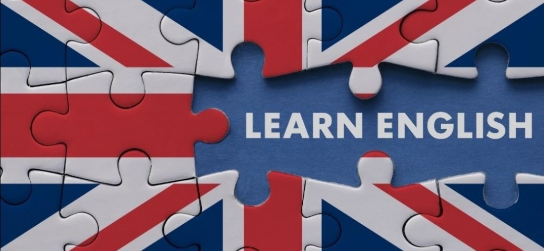 Puzzle z flagą Wielkiej Brytanii, w środku napis 'Learn English'. Grafika promująca naukę języka angielskiego, korepetycje.