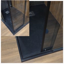 Isioland - Nowoczesny brodzik z czarnego kamienia i szklaną kabiną prysznicową z czarnymi profilami, widoczny odpływ liniowy. Minimalistyczny design, drewnopodobne płytki podłogowe.