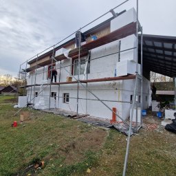 MW Docieplenia Podlasie - Ocieplanie elewacji domu jednorodzinnego styropianem, widoczne rusztowania i pracownicy. Prace w toku, Białystok.