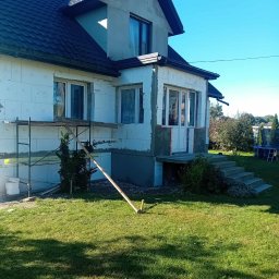 MW Docieplenia Podlasie - Dom jednorodzinny w trakcie prac elewacyjnych: ocieplenie styropianem, częściowo otynkowany, z rusztowaniem i elementami przygotowawczymi na trawniku.