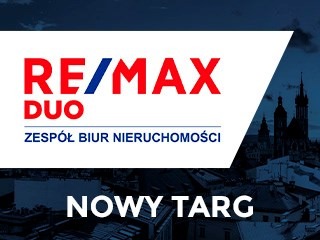 Logo RE/MAX DUO Zespół Biur Nieruchomości na tle panoramy Nowego Targu z widoczną sylwetką kościoła. Ciemne tło, jasne logo.