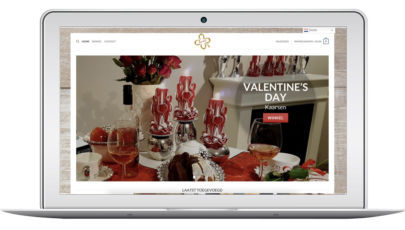 Laptop wyświetla stronę internetową barartkaarsen.nl z ofertą świec na Walentynki. Widoczne świece, wino, ciasto i dekoracje. Strona w języku niderlandzkim.