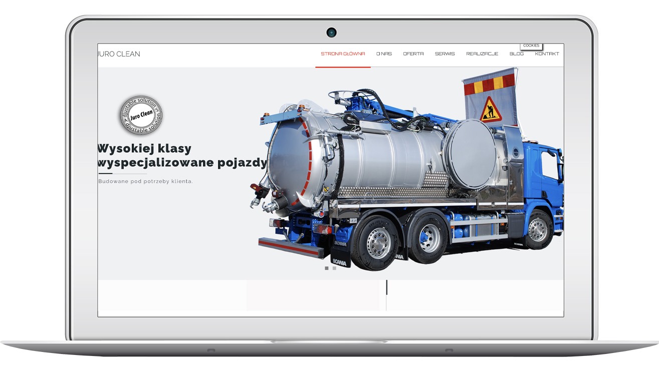 Strona internetowa juroclean.pl na laptopie prezentuje wysokiej klasy, specjalistyczny pojazd asenizacyjny. Dominuje błękit i srebro, z logo firmy w lewym górnym rogu.