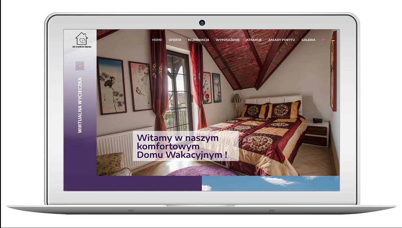 Laptop wyświetla stronę internetową allworldingdynia.com z ofertą komfortowego domu wakacyjnego. Widoczny pokój z łóżkiem i oknem balkonowym.