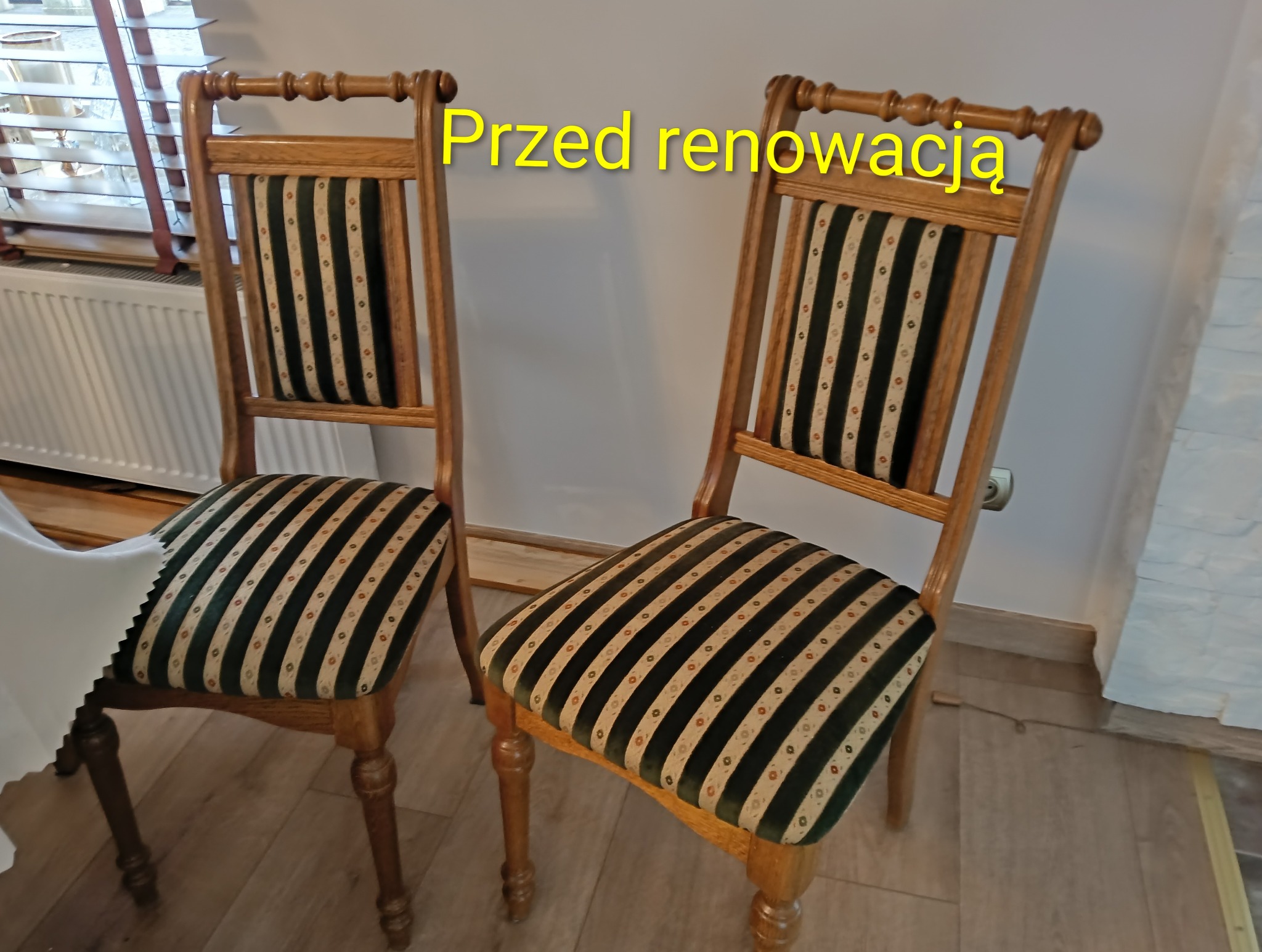 Dwa drewniane krzesła z tapicerowanymi siedziskami w paski, oznaczone jako 'Przed renowacją'. Widoczne detale wykończenia i wzór tapicerki.