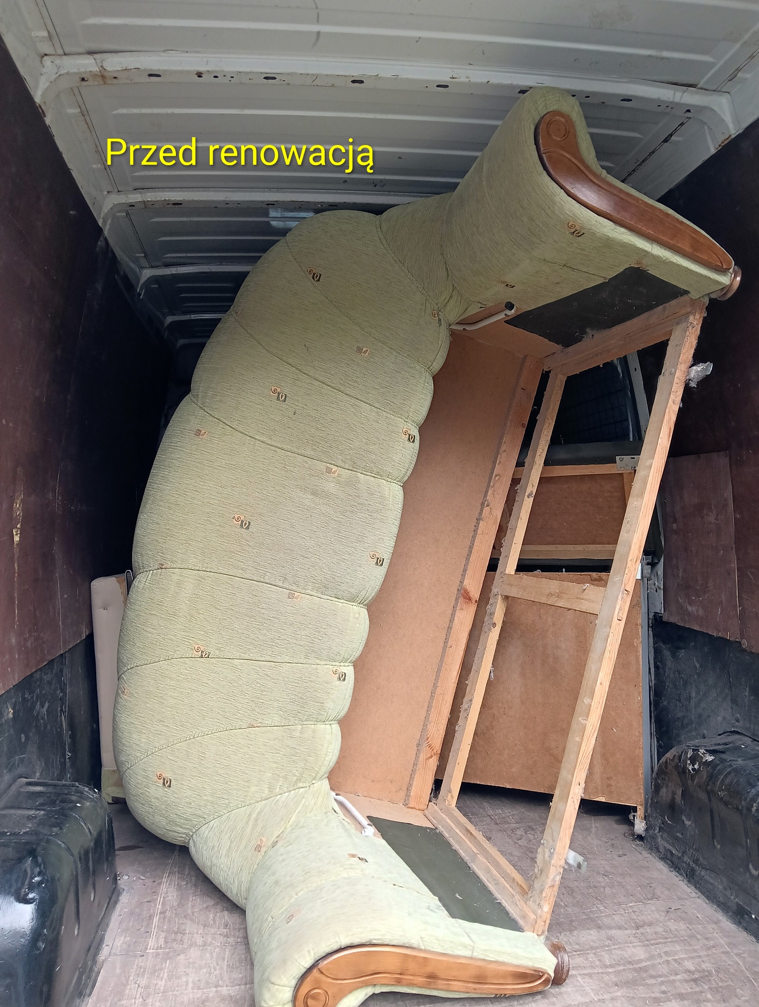 Tapicerowany fotel wewnątrz furgonetki, przed renowacją. Widoczna drewniana konstrukcja i zużyta tapicerka w odcieniach zieleni. Transport mebla do renowacji.