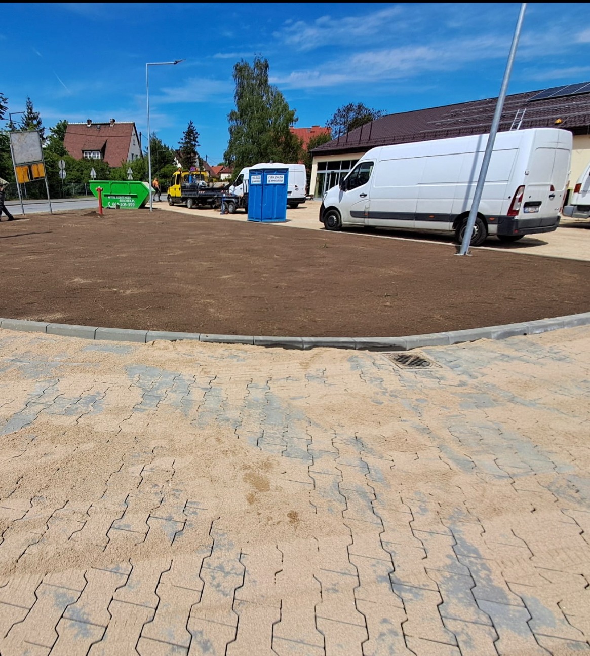 Układanie przemysłowej kostki brukowej, przygotowanie terenów zielonych i wysiew trawy.