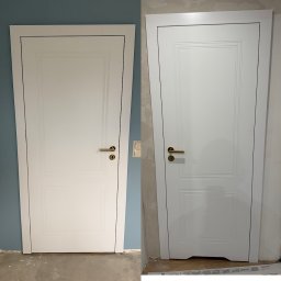 PRO MONTAŻ - Białe drzwi wewnętrzne z ozdobnymi frezami i złotą klamką, widok przed i po montażu na tle niebieskiej i białej ściany. Drobne niedoskonałości wykończenia.