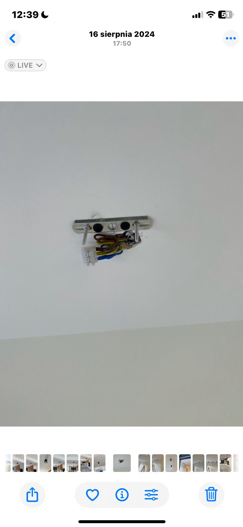 Metalowa listwa montażowa do lampy sufitowej z widocznymi przewodami elektrycznymi i kostkami połączeniowymi na białym suficie. Przygotowanie do montażu oświetlenia.