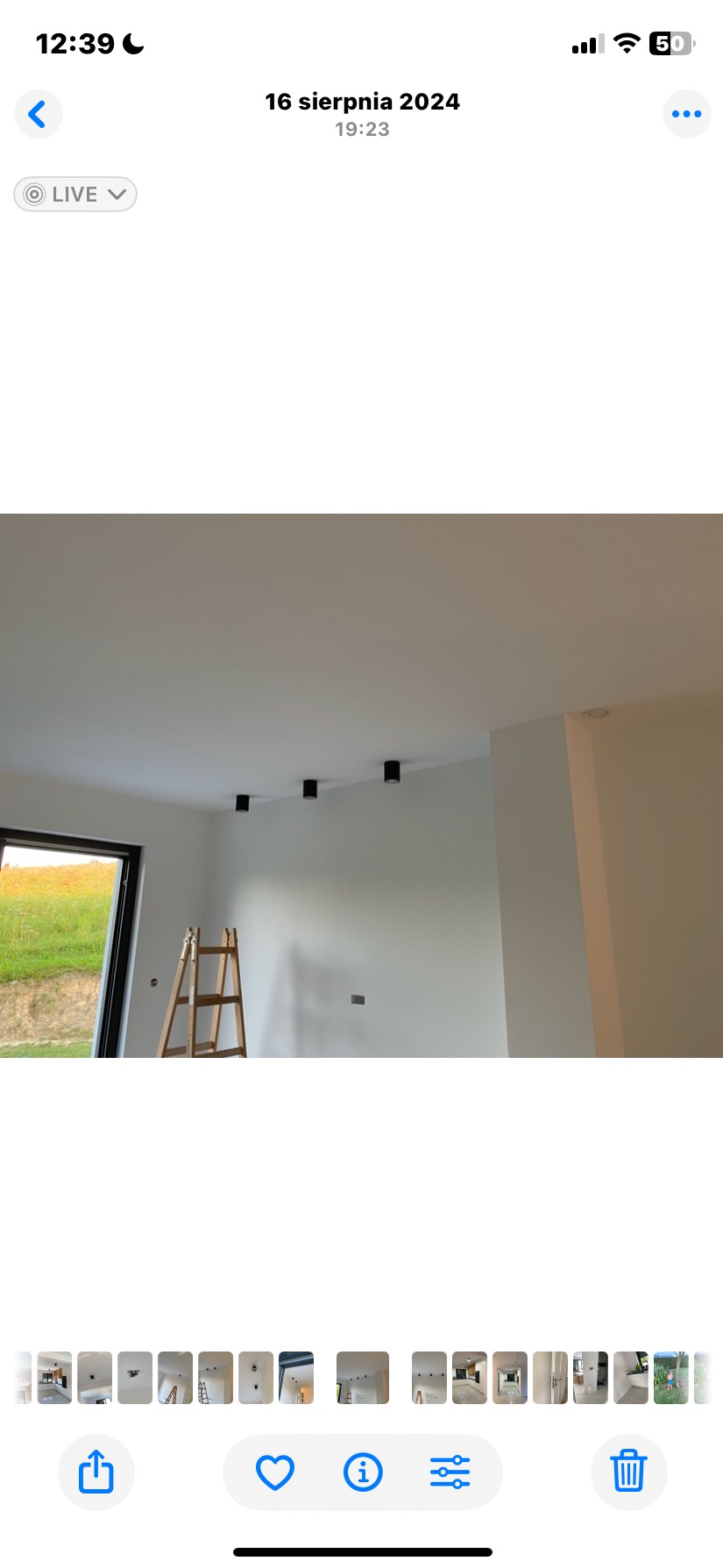 Wnętrze po malowaniu w Kątach: białe ściany, czarne lampy sufitowe, drabina przy oknie. Minimalistyczny styl, świeżo po remoncie.