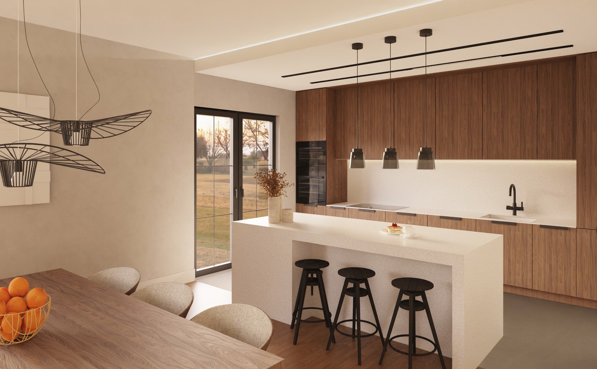 Nowoczesna kuchnia z wyspą i drewnianymi szafkami. Nad wyspą wiszą trzy czarne lampy. W tle widoczne okno z widokiem na zieleń i stół z owocami.