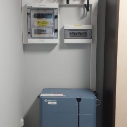 Sun Tech Fotowoltaika Rainczuk Sebastian - Kompletna instalacja fotowoltaiczna wewnątrz budynku: magazyn energii, inwerter i rozdzielnia elektryczna. Elementy marki Solplanet, schludny montaż.