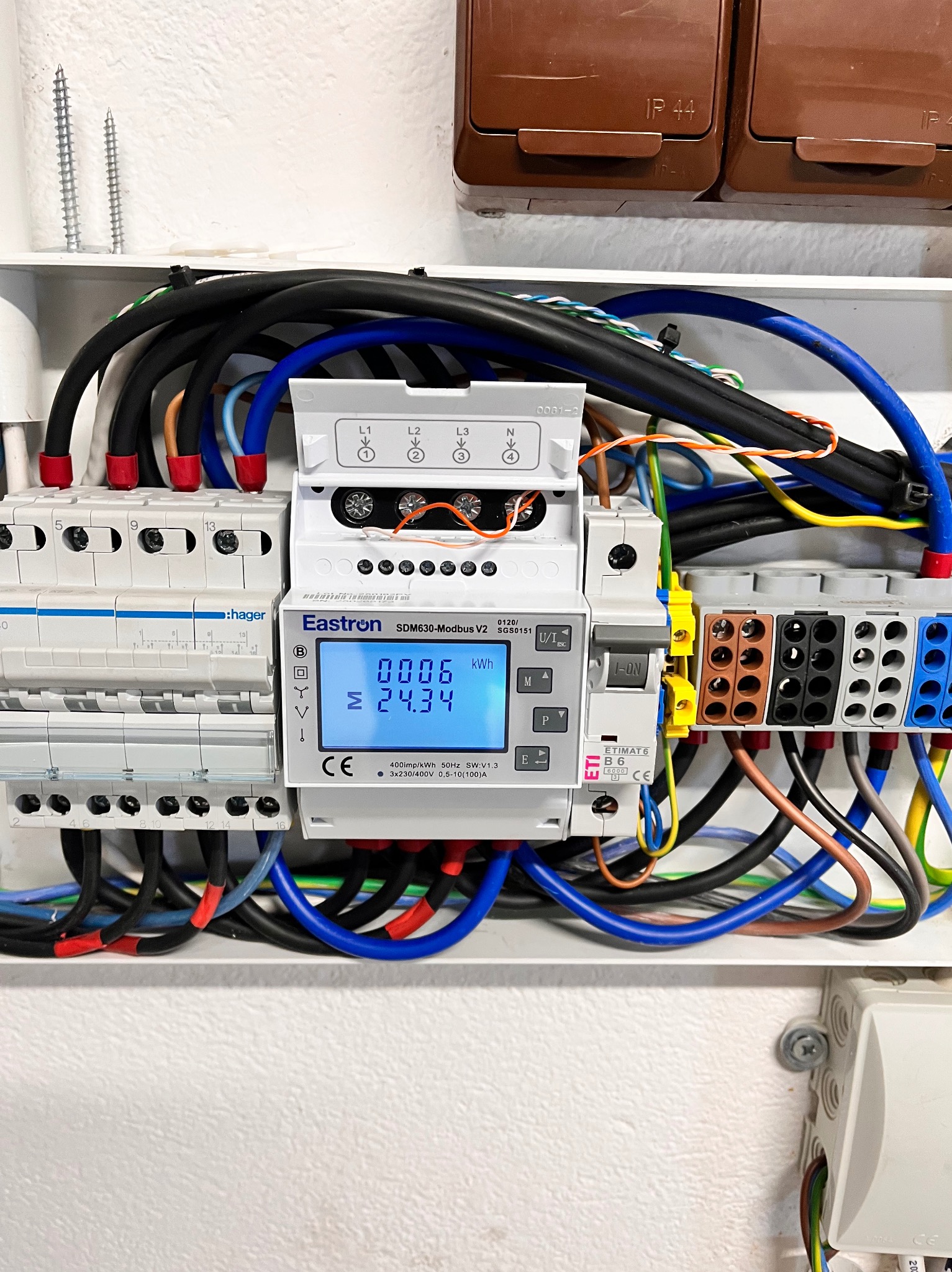 Rozdzielnica elektryczna z licznikiem Eastron SDM630-Modbus V2, widoczne przewody, bezpieczniki Hager i złącza ETIMAT 6. Instalacja w białej obudowie.