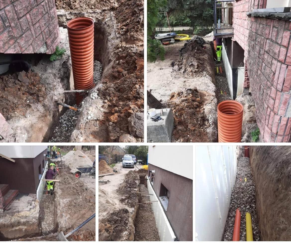 Wykop z pomarańczową rurą kanalizacyjną i podsypką żwirową wzdłuż fundamentu budynku. Widoczne etapy prac ziemnych i instalacyjnych.