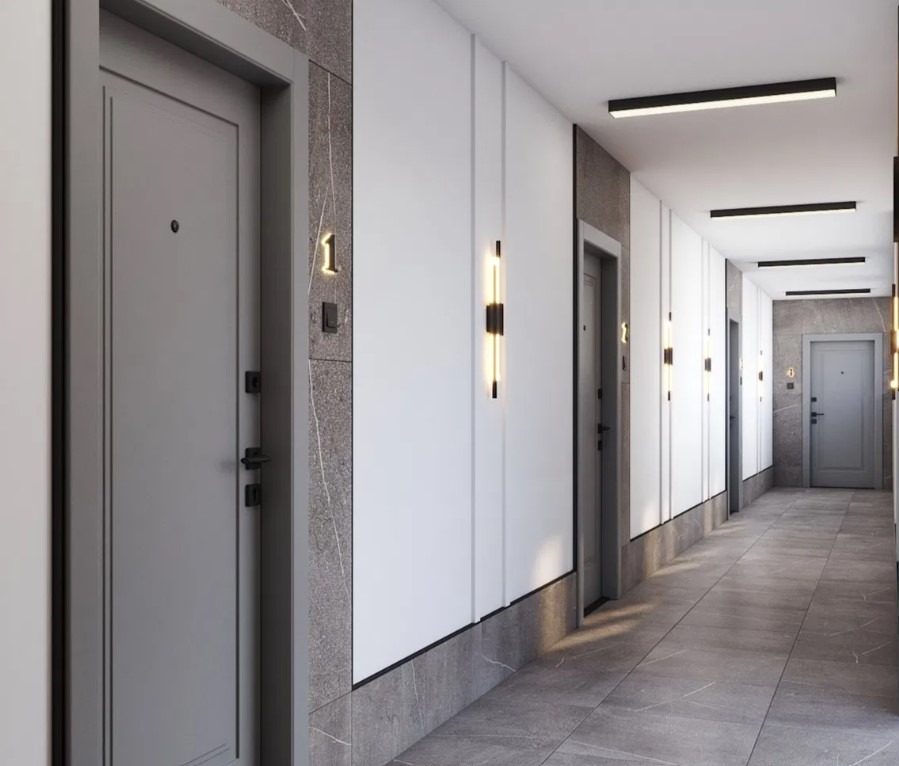 Korytarz w nowoczesnym apartamentowcu z szarymi drzwiami o numerze 1, minimalistycznymi lampami ściennymi i marmurową podłogą. Perspektywa w głąb korytarza.