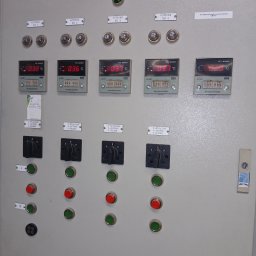 EI-ELEKTRYK Sp. z o.o. - Panel sterowania wentylacją komór transformatorowych w Białymstoku. Widoczne wskaźniki temperatury, przełączniki i przyciski sterujące. Szara obudowa, etykiety opisowe.