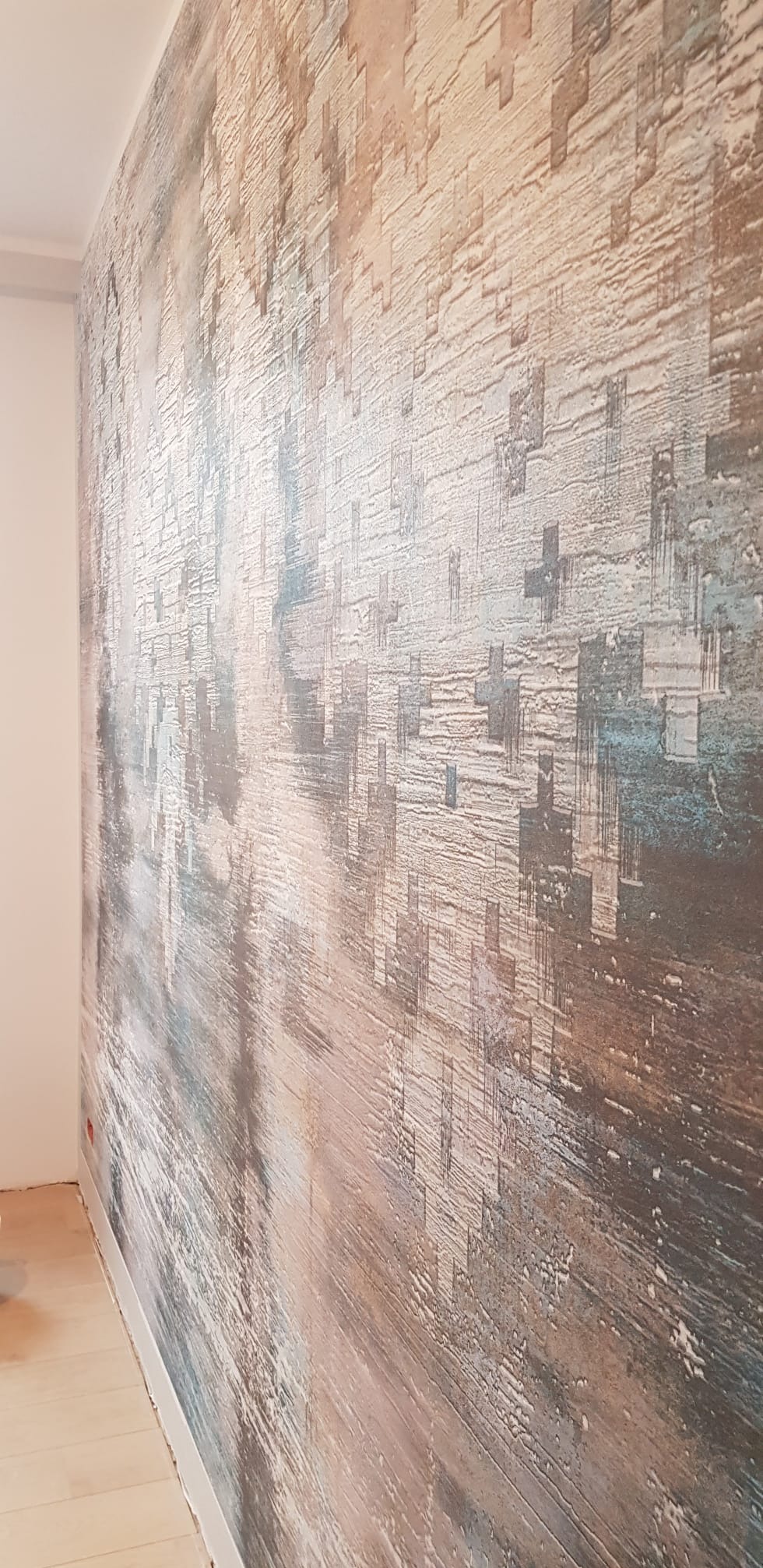 Dekoracyjna ściana z efektem strukturalnym w odcieniach brązu, beżu i błękitu. Unikalna faktura i wzór imitujący piksele. Widok z boku, podkreślający trójwymiarowość.